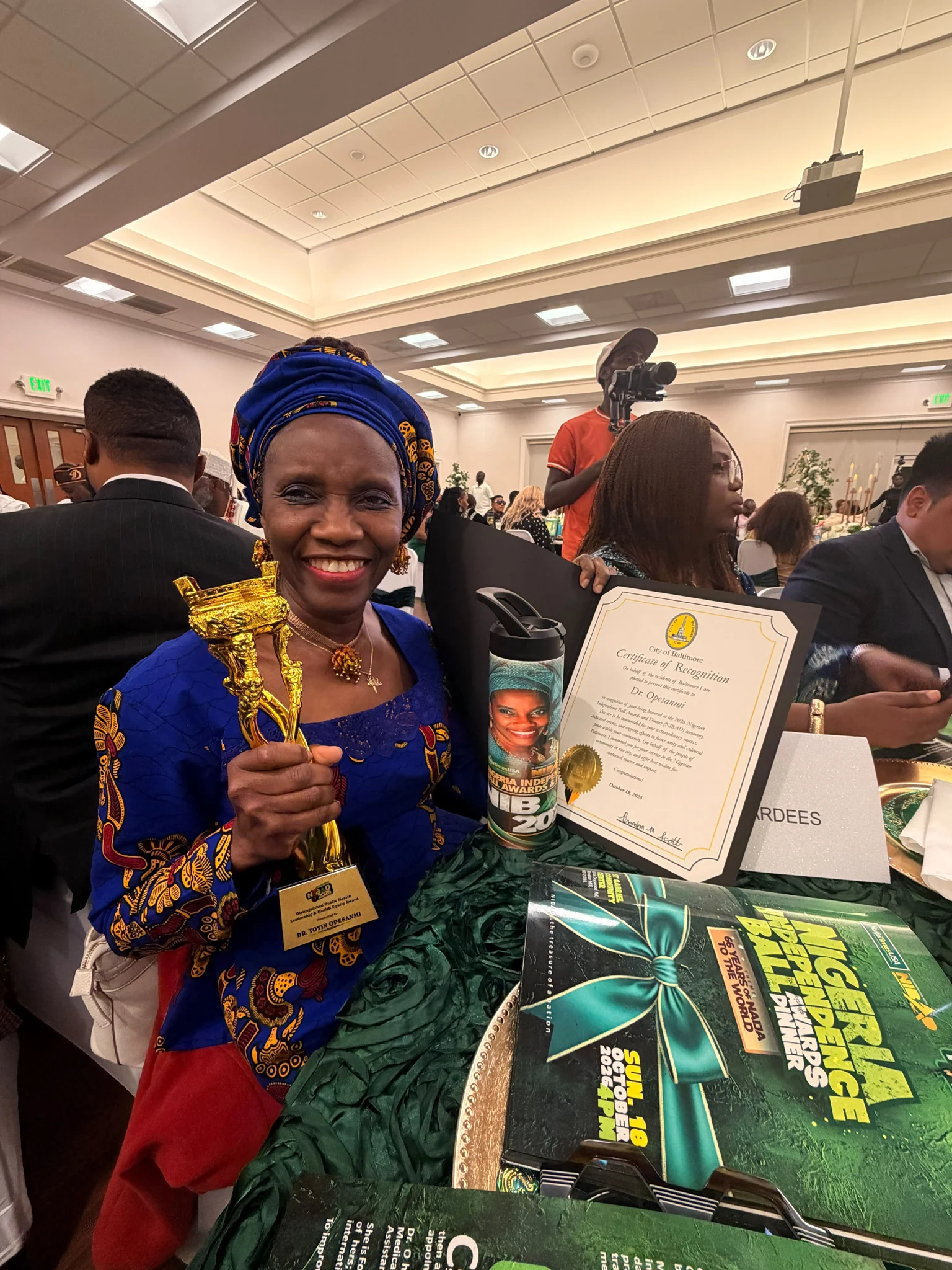 Dr. O smiling with an award and certificate at the NIBAD celebration.